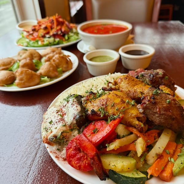 A table laden with Indian dishes, including tandoori chicken, rice, vegetables, soup, and appetizers.