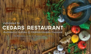 Fresh gains, spices, and veggies laying on a table surrounding the Cedars Restaurant logo.