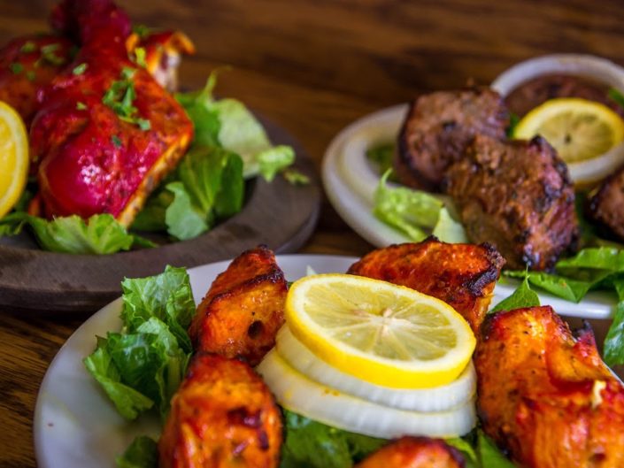 A Tandoori Chicken dish in flavorful, fresh ground spices and, served with sliced onions and lemons.