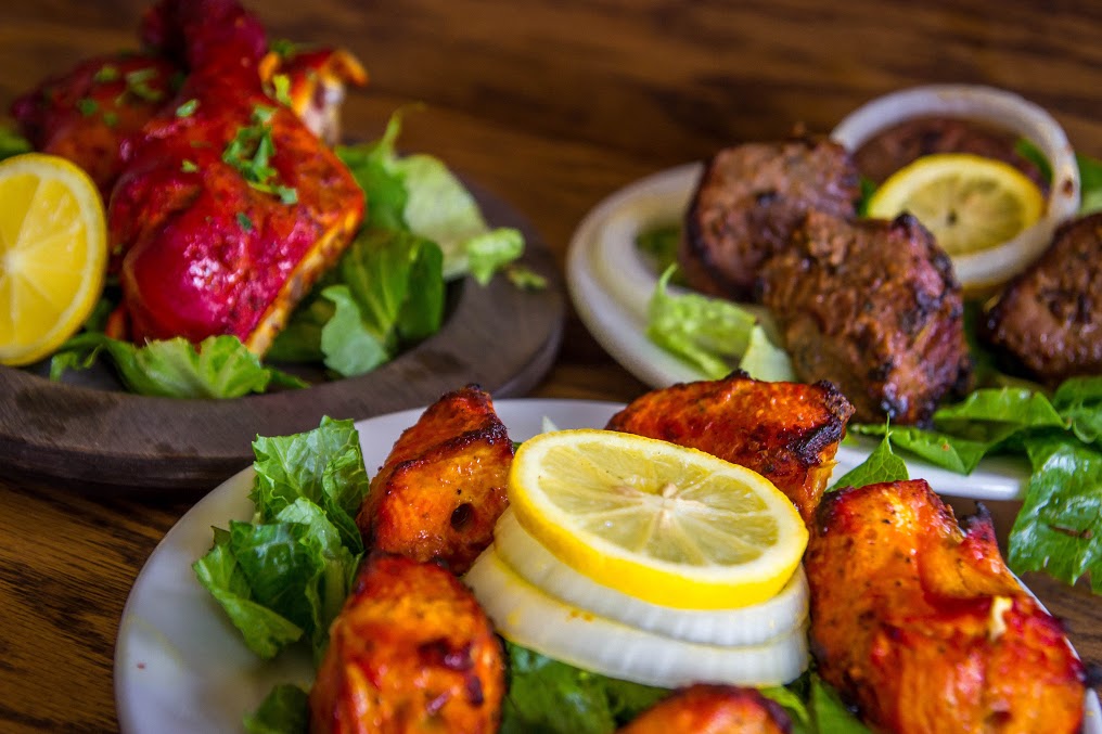 A Tandoori Chicken dish in flavorful, fresh ground spices and, served with sliced onions and lemons.